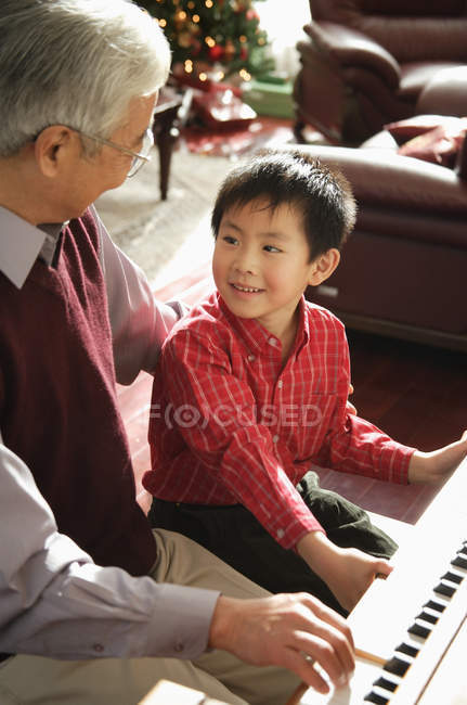 Grand-père et petit-fils jouant du piano — Photo de stock