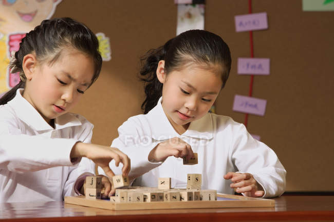 Schoolgirls in class playing with blocks — Stock Photo