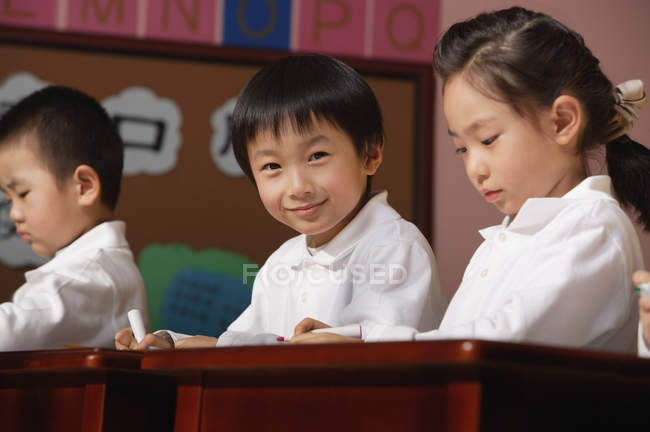 Students sitting on tables in class — Stock Photo