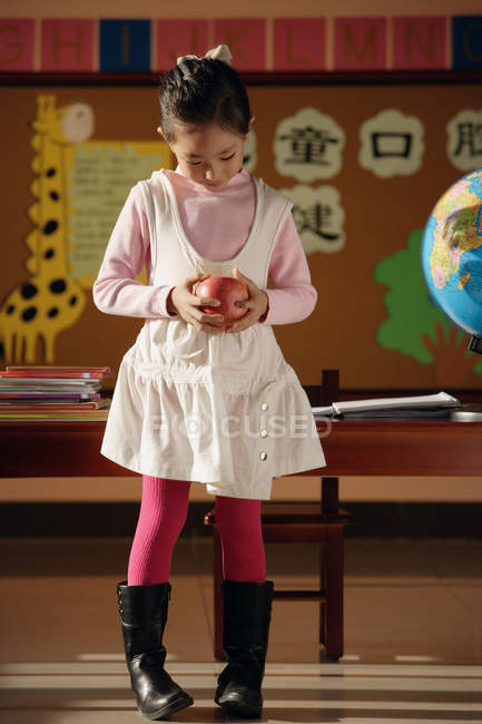 Student standing with apple in hands — Stock Photo