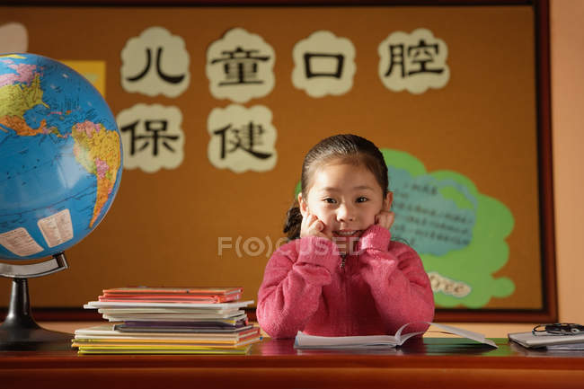 Fille assise en classe — Photo de stock