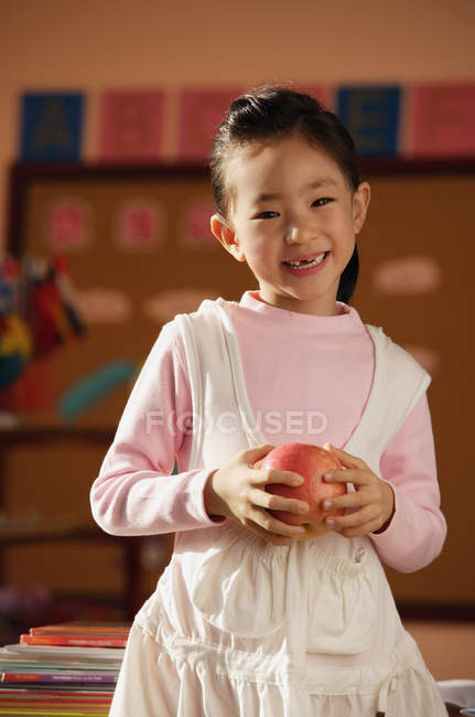 Студент стоїть з яблуком в руках — стокове фото