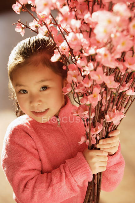 Asiatisches Mädchen mit Kirschblütenzweigen — Stockfoto