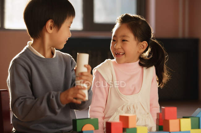 Хлопчик і дівчинка граються з будівельними блоками — стокове фото