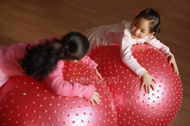 Two girls leaning on fitness balls — Stock Photo
