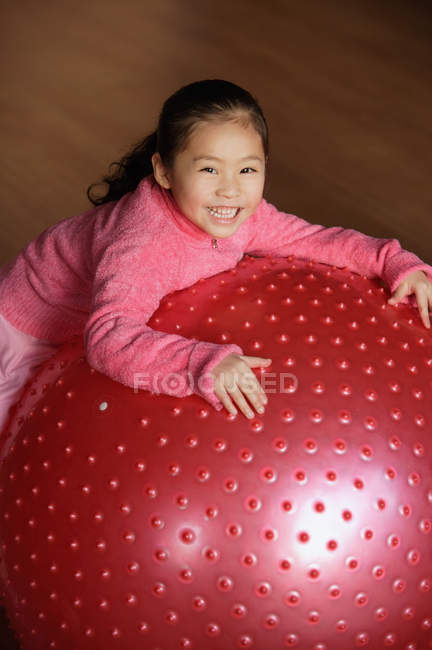 Маленькая девочка опирается на фитнес-мяч — стоковое фото