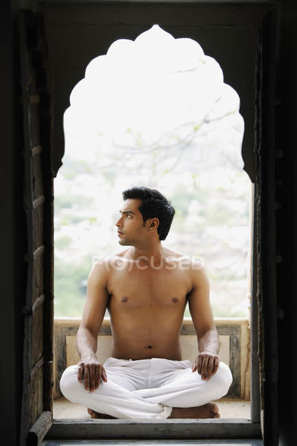 Hombre meditando en la puerta - foto de stock