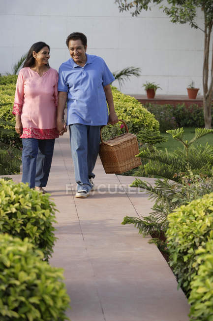 Caminhada de casal com cesta de piquenique — Fotografia de Stock
