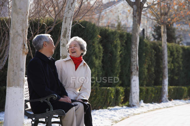 Elderly couple sitting on park bench — Stock Photo