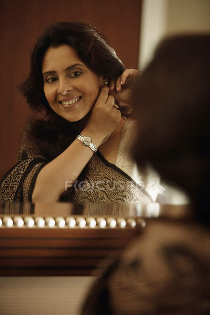 Donna guardando nello specchio — Foto stock