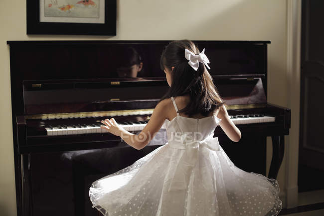 Молодая девушка играет на пианино — стоковое фото