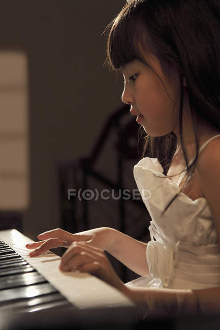 Giovane ragazza che suona il pianoforte — Foto stock
