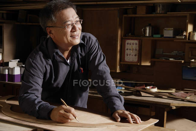 Carpinteiro trabalhando com madeira na mesa — Fotografia de Stock