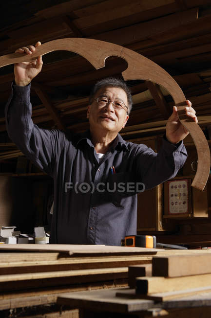 Craftsman looking at creation in artisan shop — Stock Photo