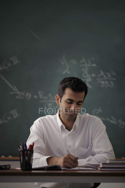 Homem sentado na mesa e escrevendo — Fotografia de Stock
