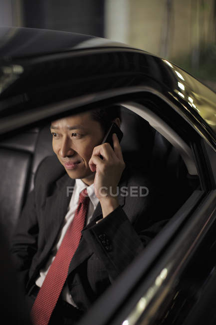 Бізнесмен сидить в машині і розмовляє по телефону — стокове фото