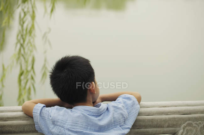 Young boy looking at lake. — Stock Photo