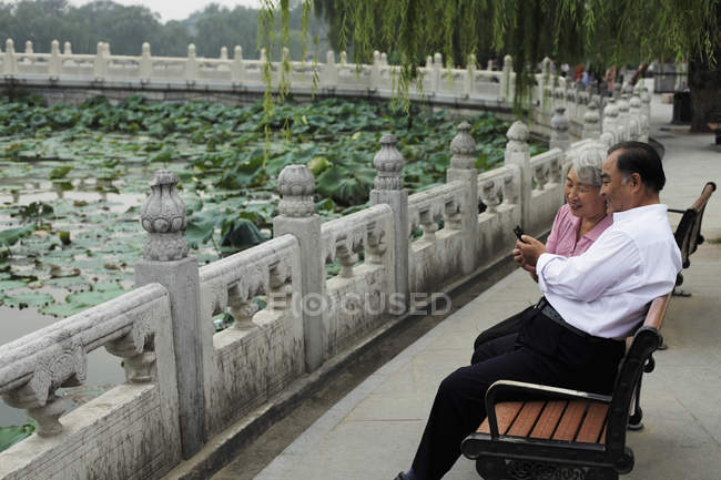 Casal sênior sentado no banco do parque — Fotografia de Stock