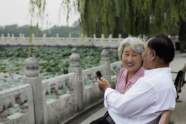 Senior couple sitting on park bench — Stock Photo