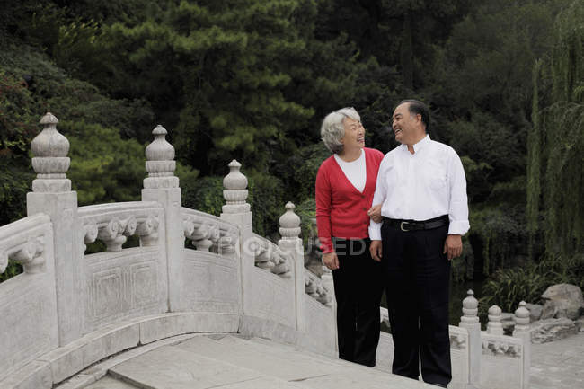 Senior couple walking on bridge — Stock Photo