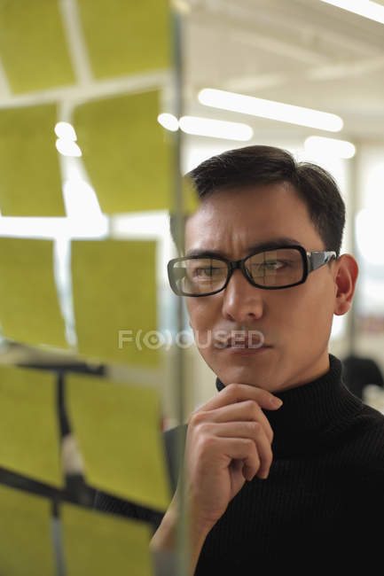 Man looking at sticky notes — Stock Photo