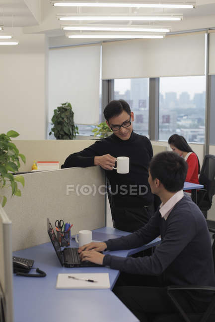 Uomo con tazza che parla con un collega — Foto stock