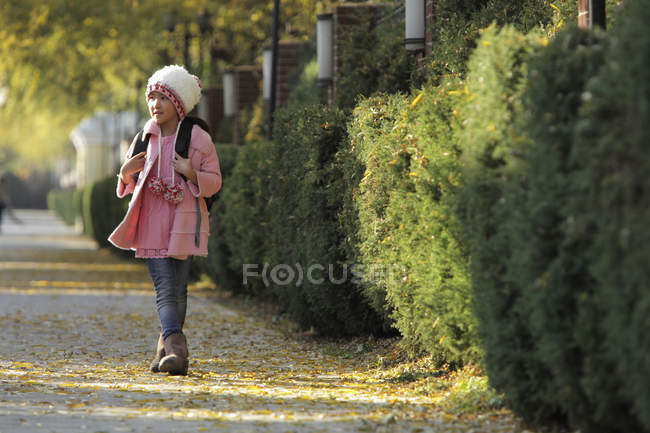 Young asian girl walking down sidewalk — Stock Photo