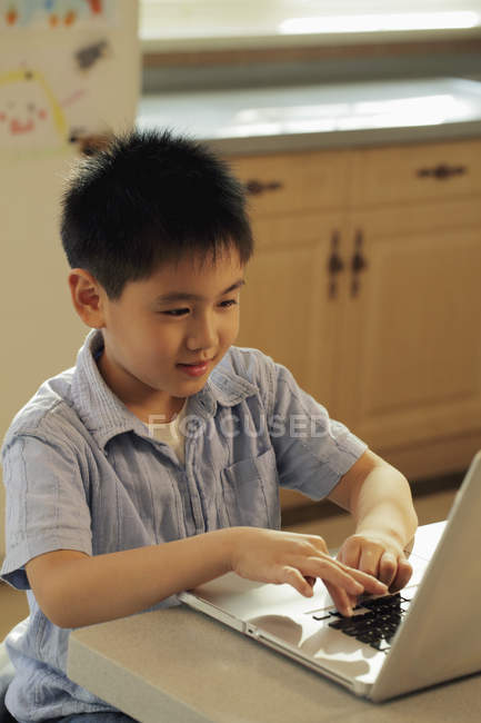 Хлопчик грає на портативному комп'ютері — стокове фото