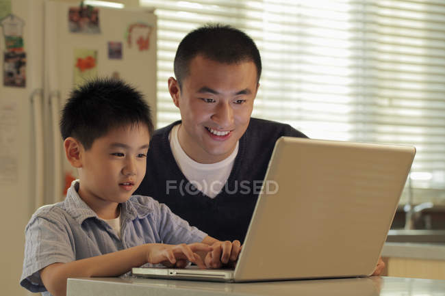 Vater und Sohn arbeiten am Laptop — Stockfoto