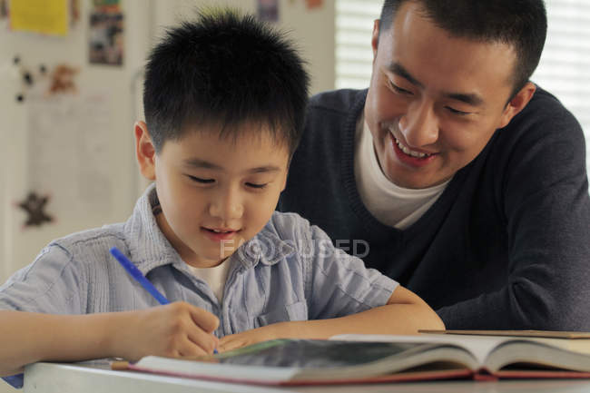 Батько допомагає синові з домашнім завданням — стокове фото