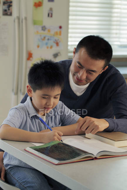 Pai ajudando filho com lição de casa — Fotografia de Stock