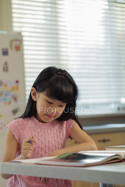 Девочка учится на кухне — стоковое фото