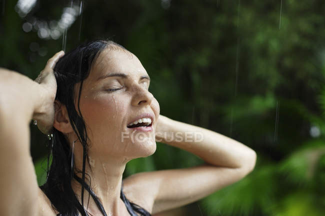 Donna sotto doccia tropicale a pioggia — Foto stock