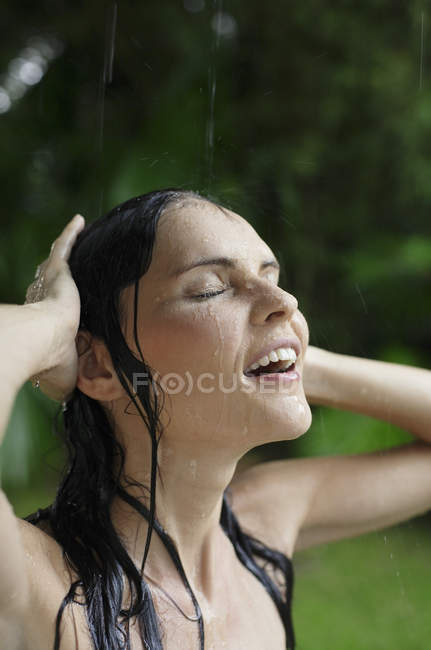 Mulher no chuveiro de chuva tropical — Fotografia de Stock