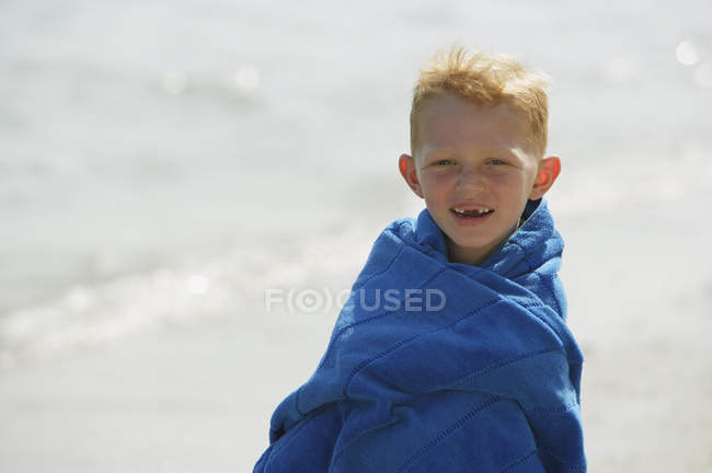 Niño envuelto en toalla azul - foto de stock