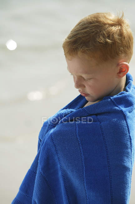Хлопчик загорнутий в синій рушник — стокове фото