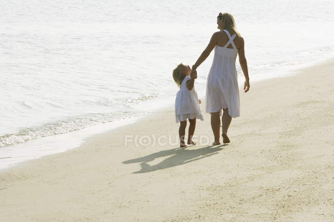 Frau mit Mädchen am Strand — Stockfoto