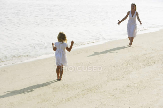 Femme avec fille sur la plage — Photo de stock