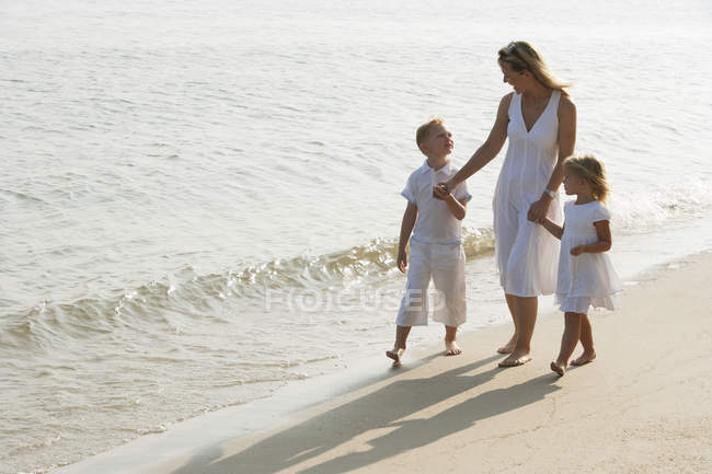Frau mit Kindern am Strand — Stockfoto