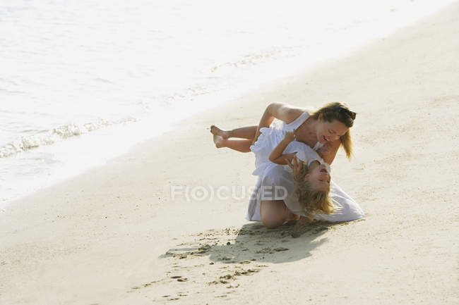 Mujer con chica en la playa - foto de stock
