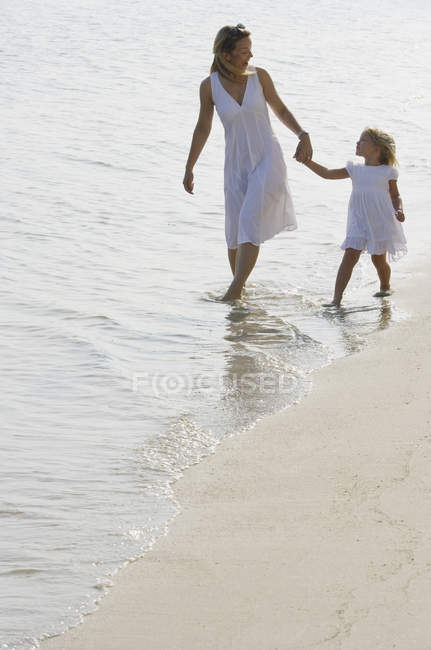 Femme avec fille sur la plage — Photo de stock