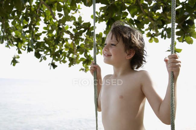 Boy standing on swing — Stock Photo