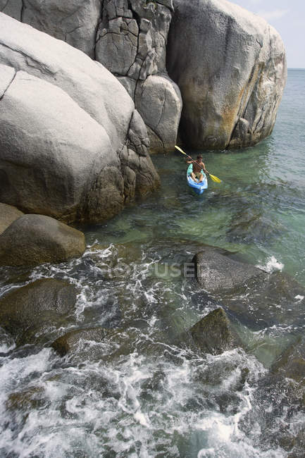Hombre kayak cerca de rocas - foto de stock