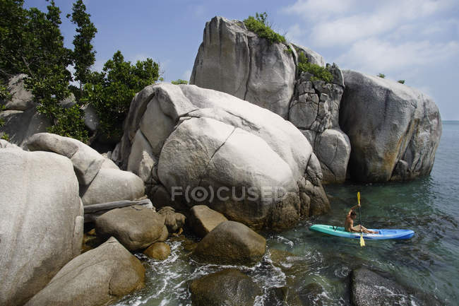 Homme kayak près des rochers — Photo de stock