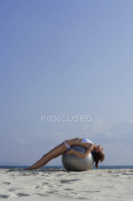 Mulher de biquíni deitada na bola — Fotografia de Stock