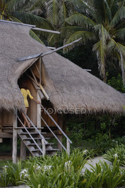 Donna che cammina in casa tropicale — Foto stock