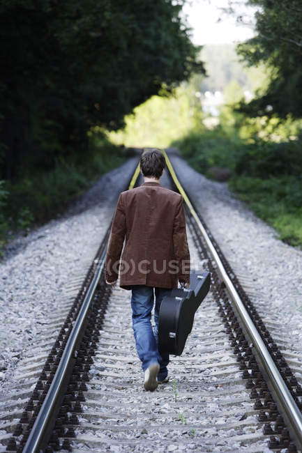 Man walking down train tracks — Stock Photo