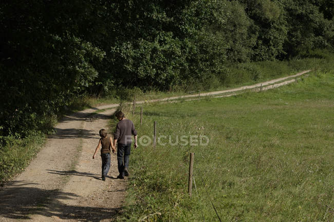 Padre e figlio camminando lungo la strada — Foto stock