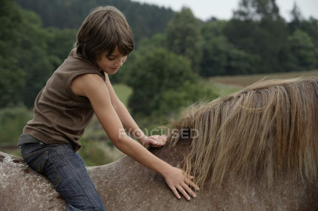 Garçon chevauchant à cheval — Photo de stock