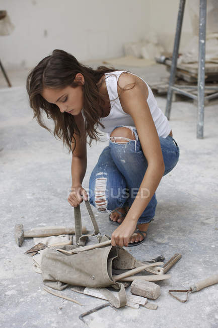 Mujer recogiendo herramientas en el estudio de arte - foto de stock